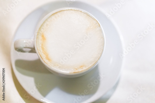 Hot coffee - cappuccino in glass mug on white background