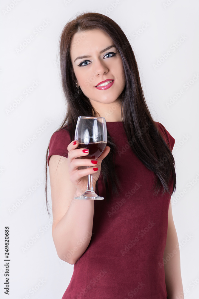 Beautiful happy young girl holding red wine glass in hand isolated on white background in studio. Alcohol drink concept. Close up, selective focus Beautiful happy young girl holding red wine glass in hand isolated on white background in studio. Alcohol drink concept. Close up, selective focus