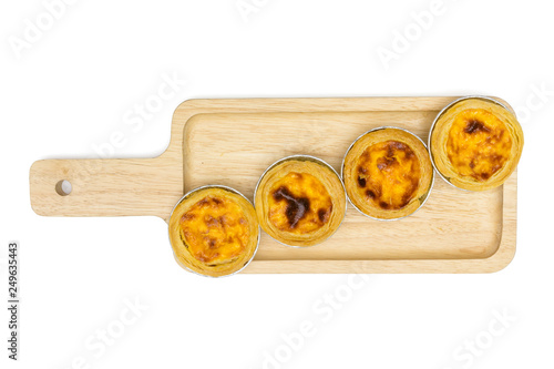egg tart in aluminum foil cup on square wooden tray, isolated on white background, top view