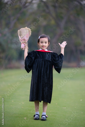 Asian cute child girl graduate. Girl smile on graduation kindergarten uniform