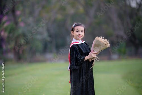 Asian cute child girl graduate. Girl smile on graduation kindergarten uniform