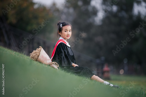 Asian cute child girl graduate. Girl smile on graduation kindergarten uniform