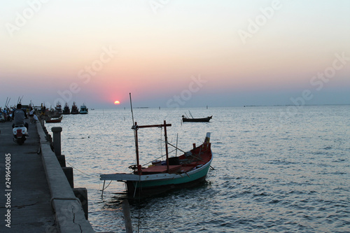 small fishing boat in the sea and harbor and sunset sky background