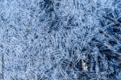 close up of dense ice crystal filled pond surface texture background on cold winter day