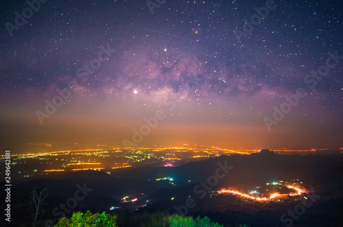 Long exposure night shot of Milky way in the great Universe over the Phu Tub Berk city Phetchabun province,Thailand with city lights at night.