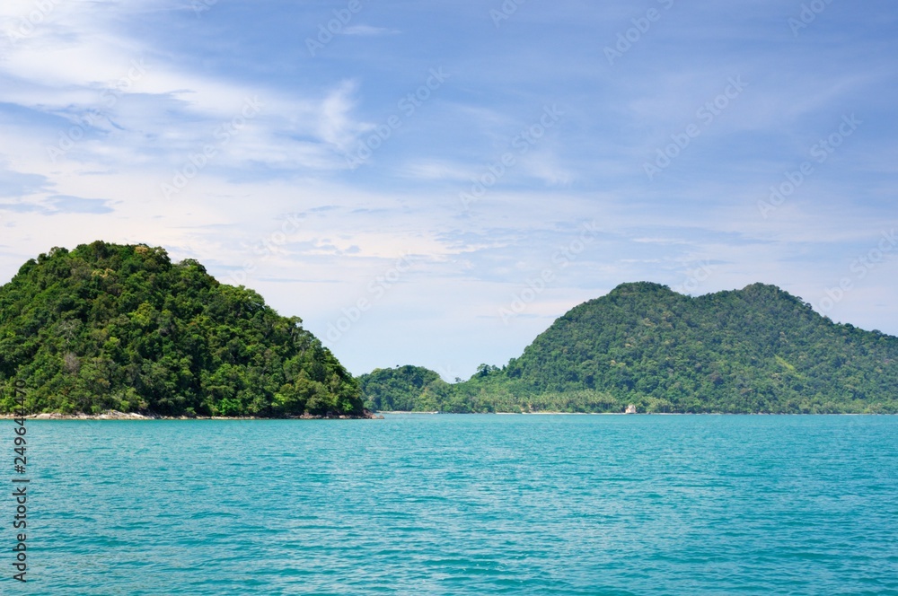 Landscape with turquoise tropical sea, dark blue sky with white clouds and tropical Koh Chang island on horizon in Thailand