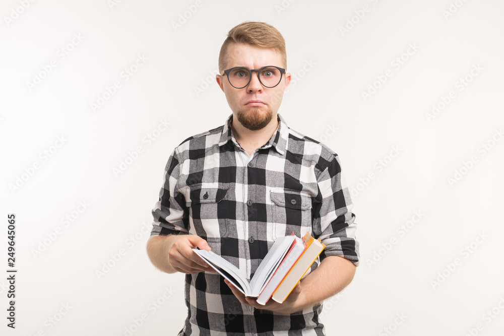 Exam, knowledge and education concept - Surprised student man holding books in his hands on white background Exam, knowledge and education concept - Surprised student man holding books in his hands on white background