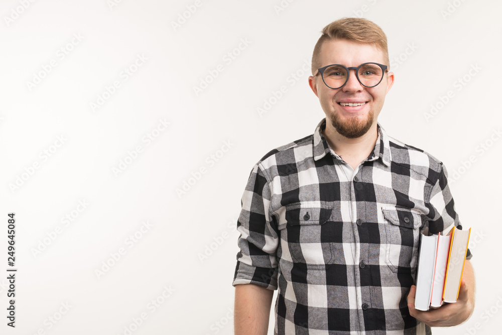 Exam, knowledge and education concept - Portrait of a student man holding books in his hands on white background with copy space Exam, knowledge and education concept - Portrait of a student man holding books in his hands on white background with copy space