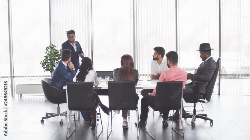 Indian awesome man is showing his plan to colleagues. successful businessmen giving advice to new employees Indian awesome man is showing his plan to colleagues. successful businessmen giving advice to new employees