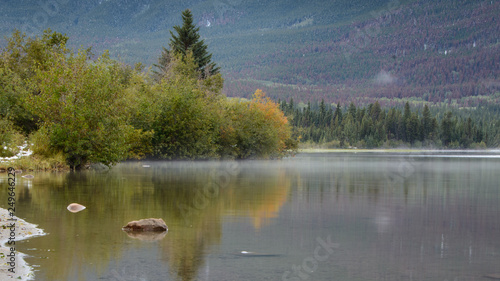 Patricia Lake with mist floating at the lake surface and autumn colours reflected in the lake, Jasper National Park, Canada