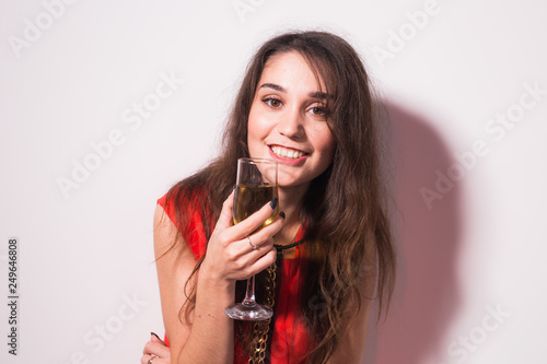 Alcohol  people and party concept - Young celebrating woman in red dress. Beautiful model hold wine glass.