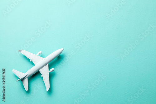 White passenger plane on green mint background. Copy space for text.