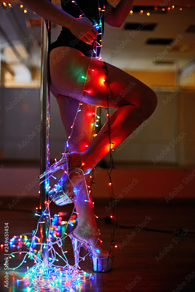 Sexy Female legs in Strip-shoes dancing on a pole silver shoes wrapped by  bunch of Christmas lights Stock Photo | Adobe Stock