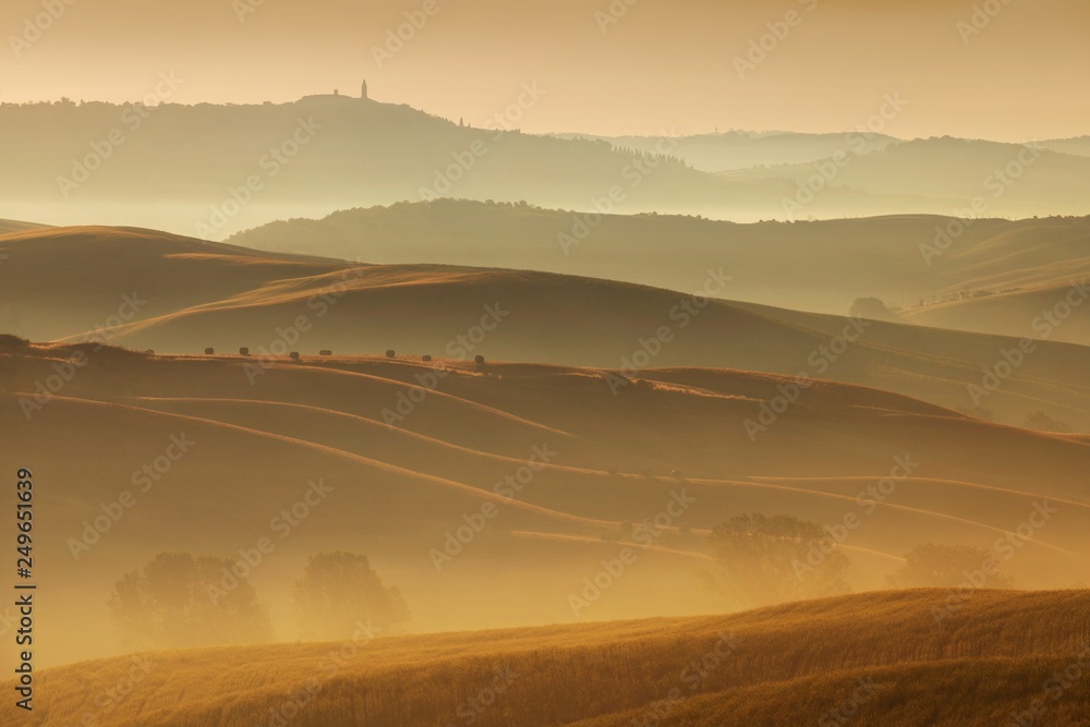 Tuscany landscape at sunrise. Typical for the region tuscan farmhouse, hills, vineyard. Italy Fresh Green tuscany landscape in spring time. Beautiful foggy landscape concept