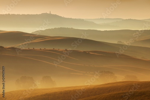 Tuscany landscape at sunrise. Typical for the region tuscan farmhouse  hills  vineyard. Italy Fresh Green tuscany landscape in spring time. Beautiful foggy landscape concept