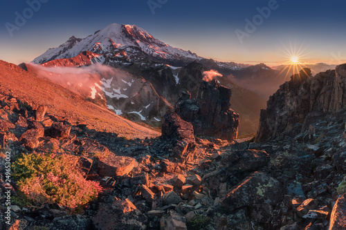 Morning light high above the cloud layer on Mount Rainier. Beautiful Paradise area, Washington state, USA in the fall with snow on Mount Rainier on a sunny day and morning with blue sky. Cascade Range