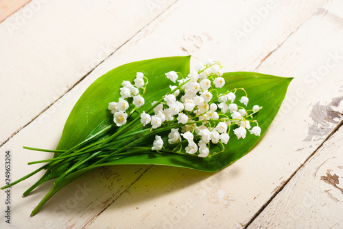 bouquet of lily of the valley flowers on old painted bright wood table background