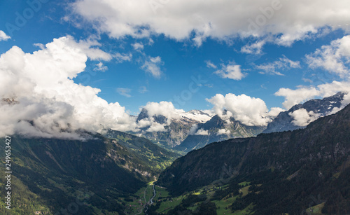Helicopter walk over the Swiss Alps in the town of Interlaken. View of the valley, alpine mountains and cloudy sky. Switzerland