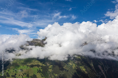 Helicopter walk over the Swiss Alps in the town of Interlaken. View of the valley, alpine mountains and cloudy sky. Switzerland