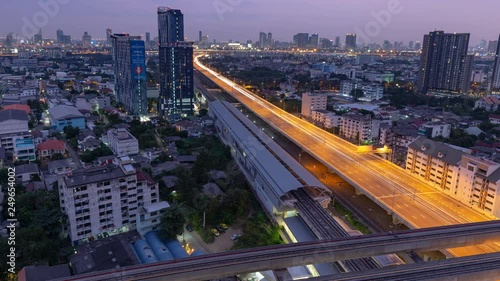 Evening imelapse of the Si Rat-Outer Ring Road Expressway, train tracks and the MRT Purple Line in Bangkok, Thailand. photo