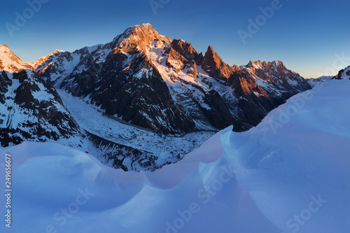 Stunning view of Mont Blanc massif and his melting glaciers. Winter adventures in the Italian French Alps. Courmayeur, Aosta Valley. Italy Val Veny, and the ski slopes of the Courmayeur ski domain. photo