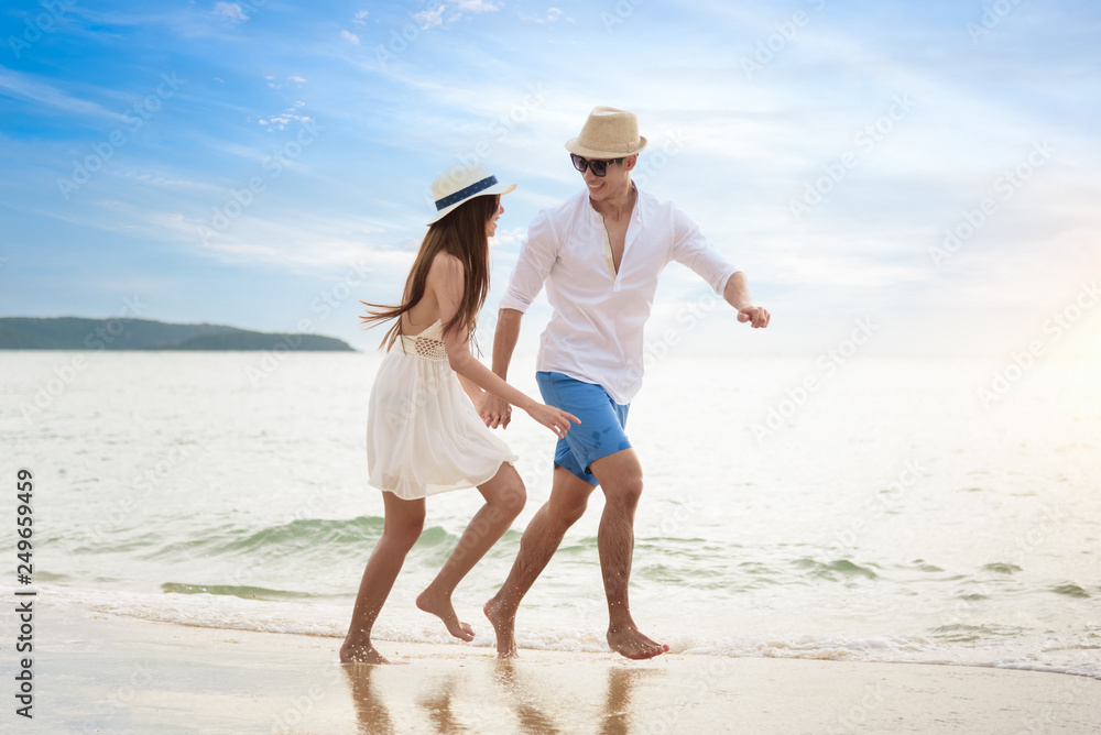Romantic couple relaxing on the beach and enjoying beautiful sea view Romantic couple relaxing on the beach and enjoying beautiful sea view