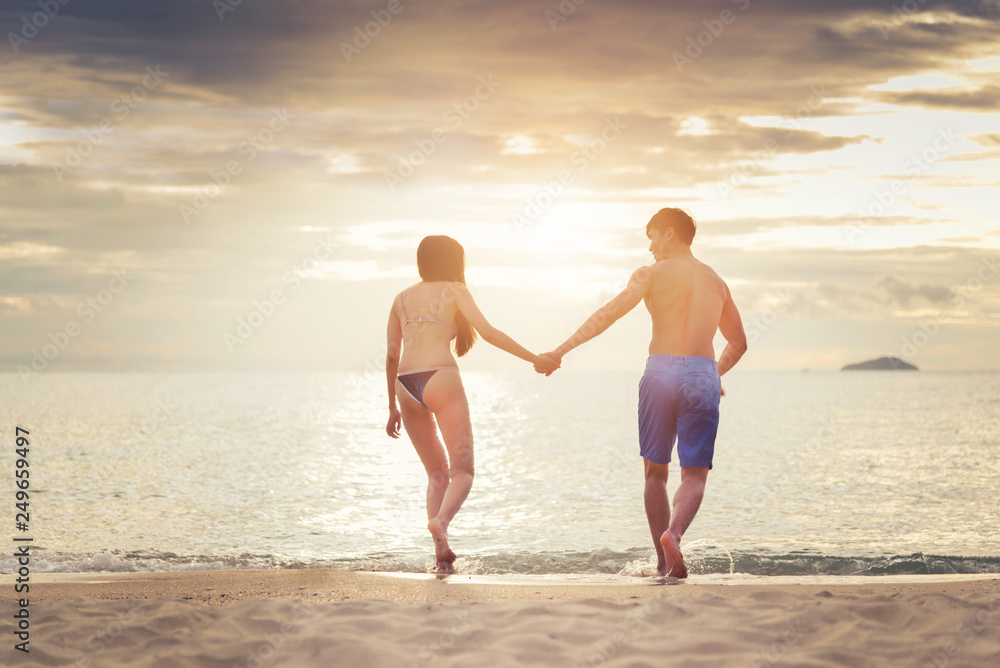 Loving couple enjoying walking on the beach enjoying