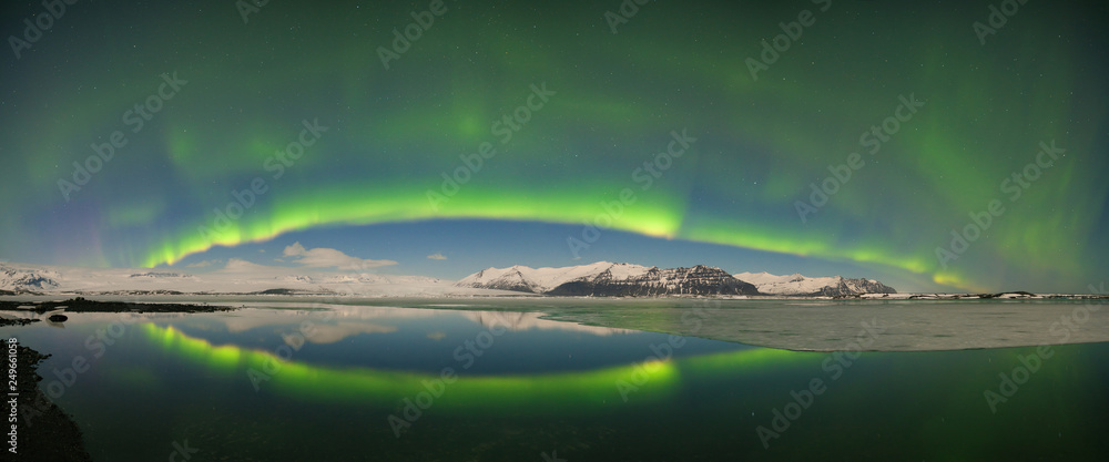 Beautiful panoramic Aurora Borealis or The Northern Lights for background view in Iceland, Jokulsarlon during winter season. Sky with stars and green polar lights. Night landscape with aurora. Concept