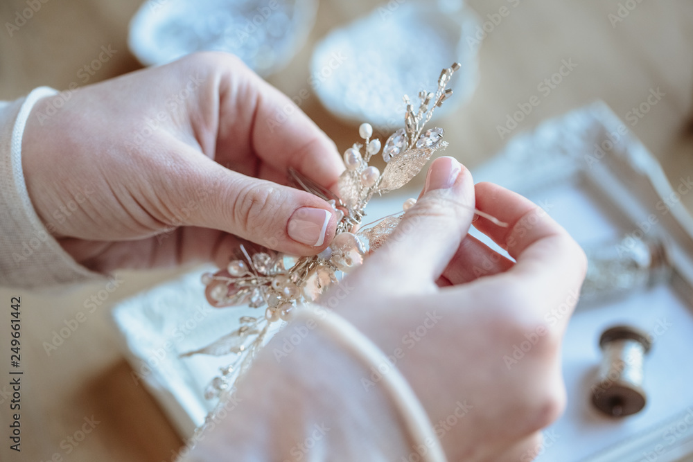 Closeup macro photo of details, workplace of decorator and creator of wedding imitation jewelry. Woman's hands in a process of creation