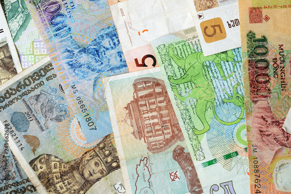 Obraz premium Different countries money background close up. Belarusian rubles, Georgian lari, Polish zloty, Israeli shekels, Vietnamese dongs