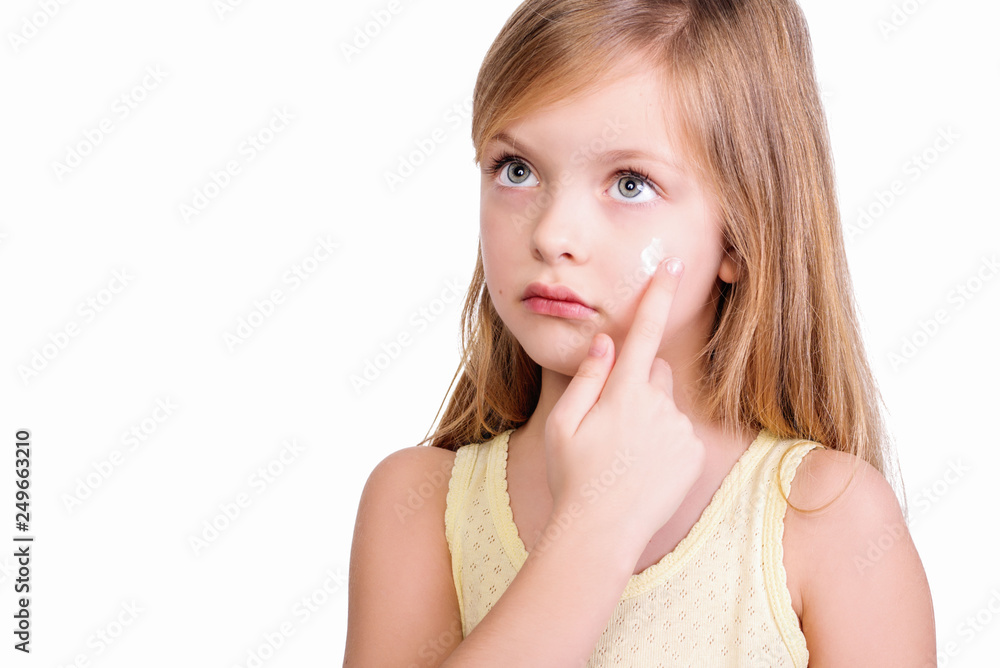Portrait of little kid applying on facial cream isolated on white Portrait of little kid applying on facial cream isolated on white