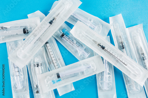 Large packages with cocaine on a blue background, medical syringe close