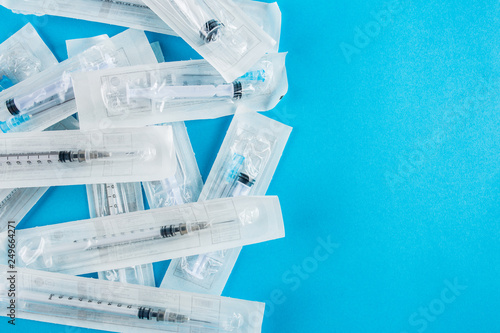Large packages with cocaine on a blue background, medical syringe close