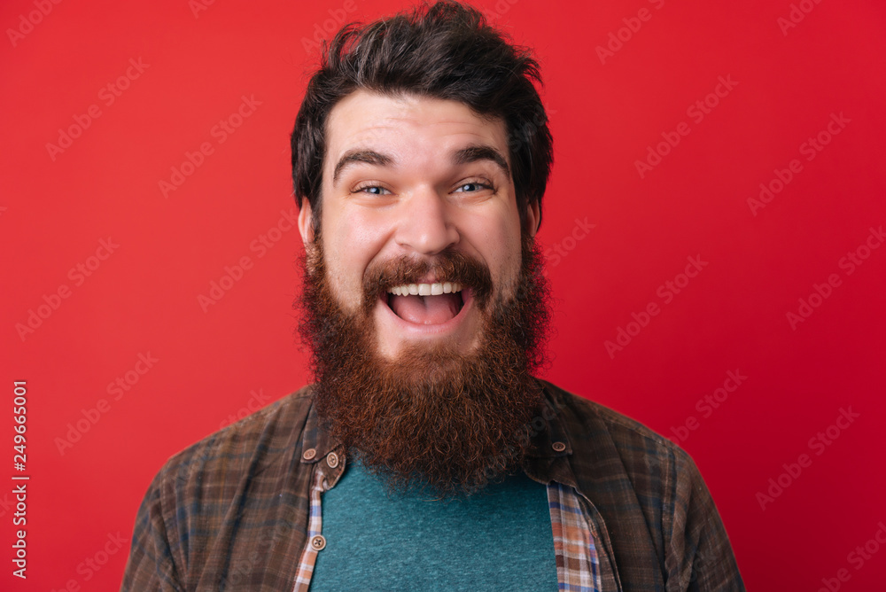 Portrait of an excited bearded man with open mouth isolated over red background Portrait of an excited bearded man with open mouth isolated over red background