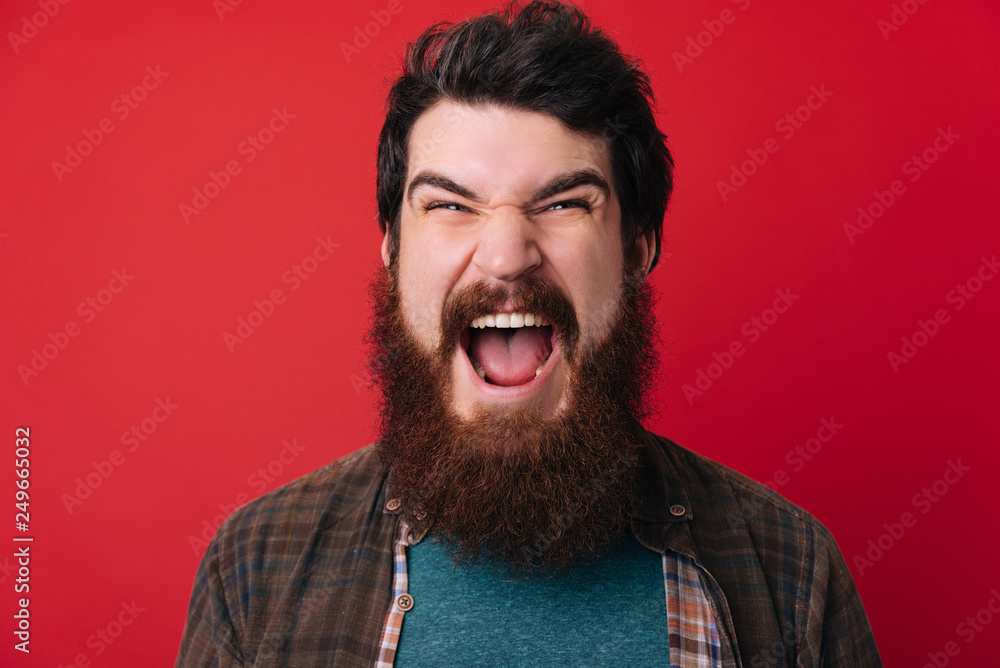 Screaming bearded brutal man and looking at the camera. Crazy man with beard Screaming bearded brutal man and looking at the camera. Crazy man with beard