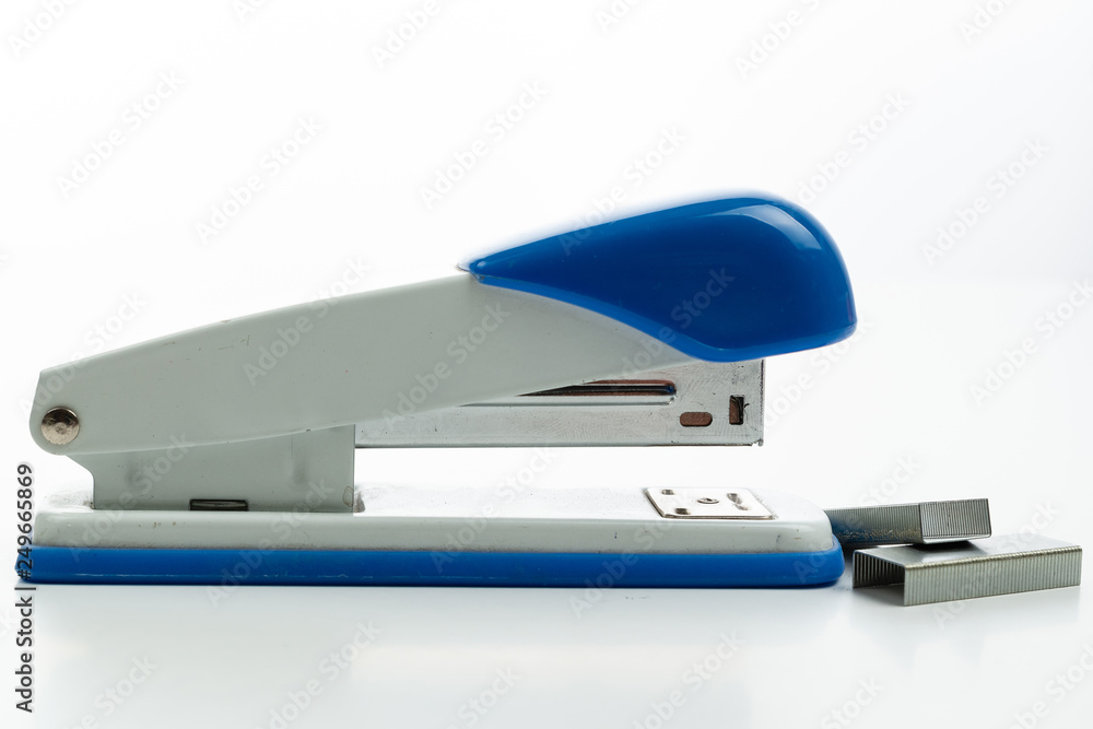 Large metal stapler close-up on white background with paper clips side view Large metal stapler close-up on white background with paper clips side view