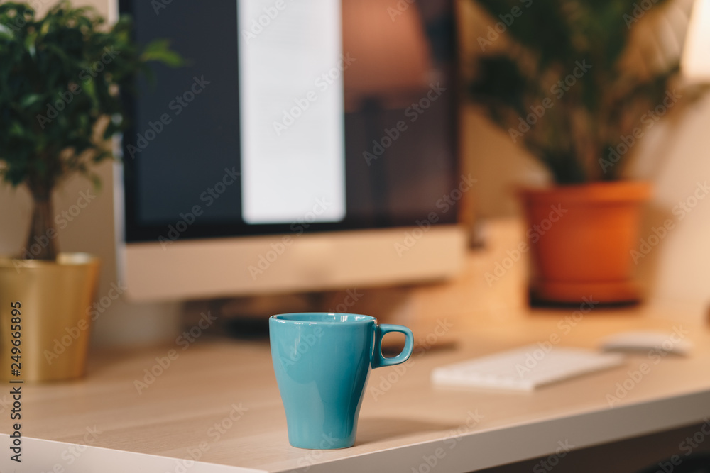Coffee cup on a wooden table, in front of the working computer. Home office concept, personal working space. Coffee cup on a wooden table, in front of the working computer. Home office concept, personal working space.