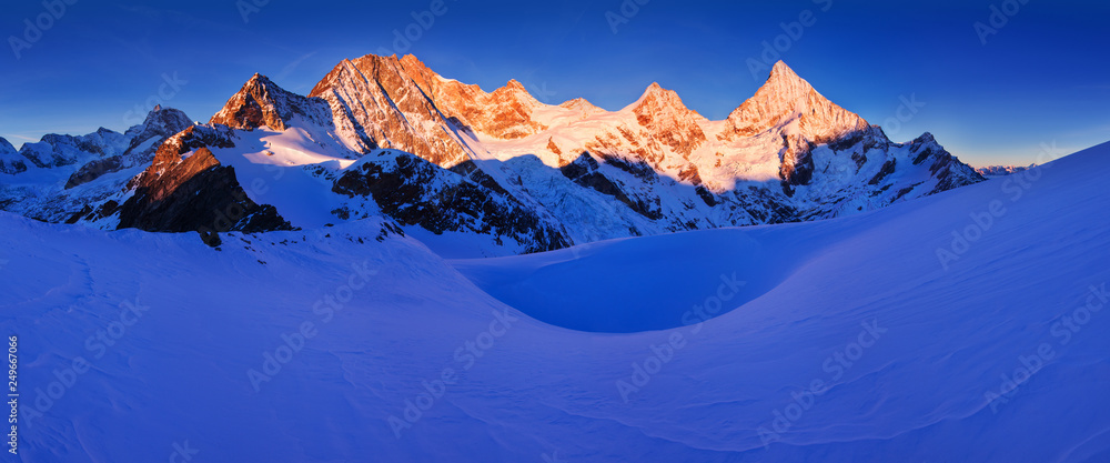 View of snow covered landscape with Dent Blanche mountains and Weisshorn mountain in the Swiss Alps near Zermatt. Panorama of the mountains in Switzerland. Beautiful morning with first snow. Christmas
