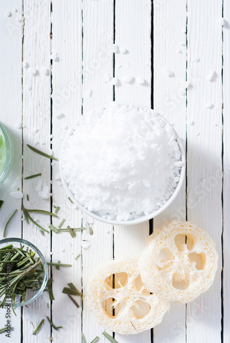 bath salt and loofah on white wood table photo