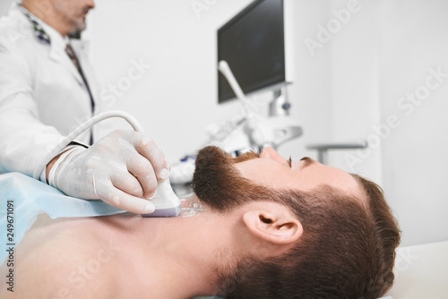 Doctor using ultrasound probe for lymph node diagnosis.
