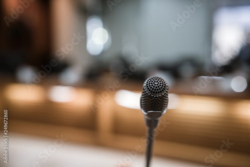 Front Microphone on abstract conference hall prepare for speaker on stage in seminar room, Business meeting and education in teaching classroom or Event light convention hall Background. photo