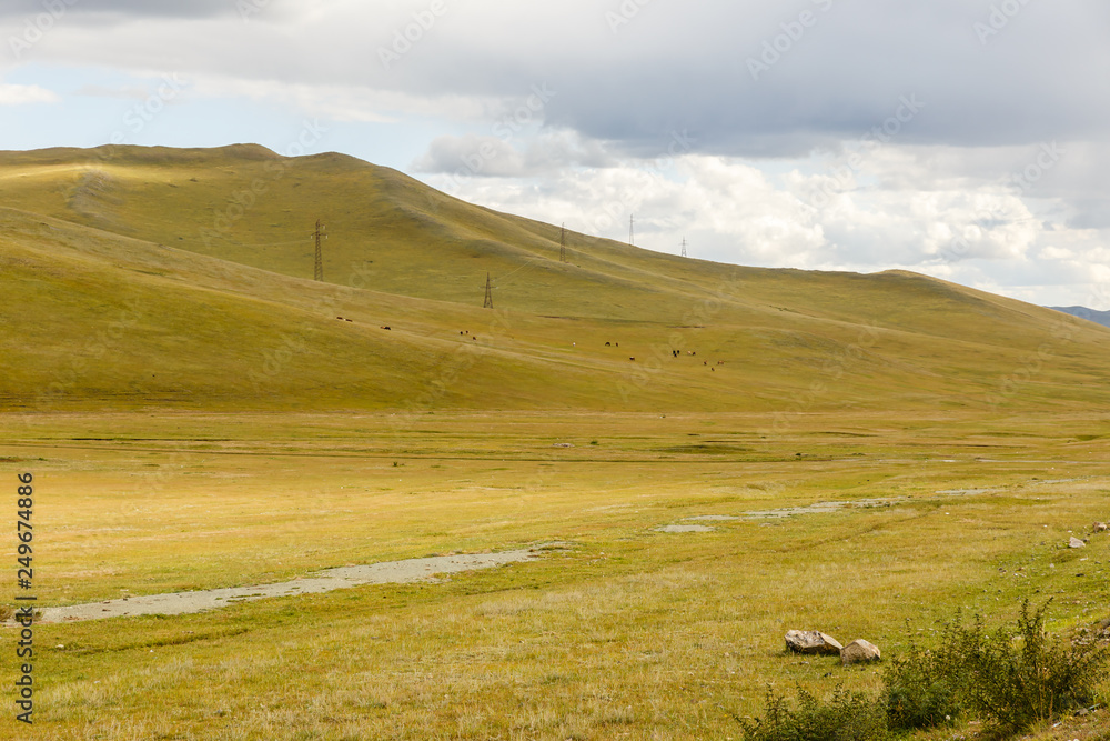 High-voltage power line runs through the hills in Mongolia, a beautiful Mongolian landscape