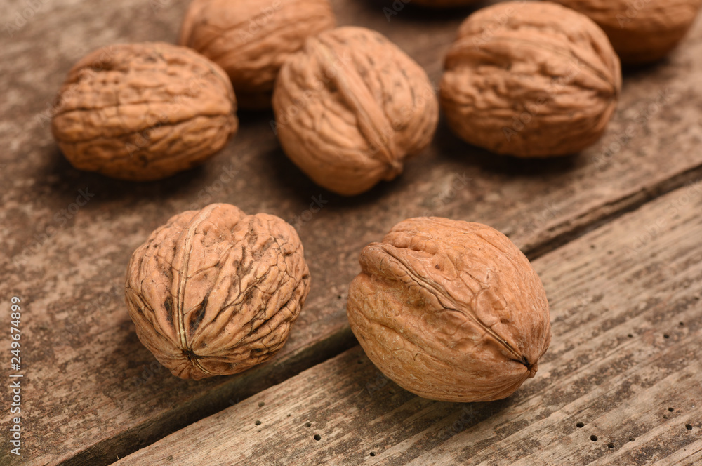 Walnut kernels and whole walnuts on rustic old oak table. Walnut kernels and whole walnuts on rustic old oak table.