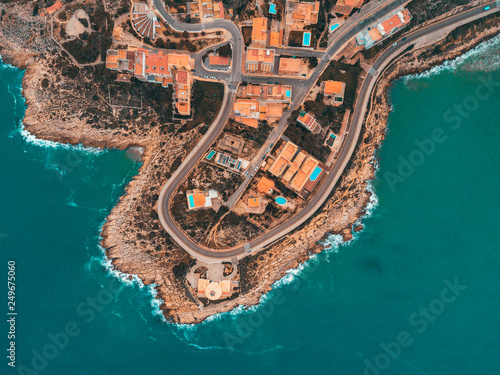 Beautiful mediterranian coastline near Valencia, Spain with small town, hotels, buildings and roads. Autumn winter blue turquoise cold sea water and warm colors coastline. Aerial drone shot view photo
