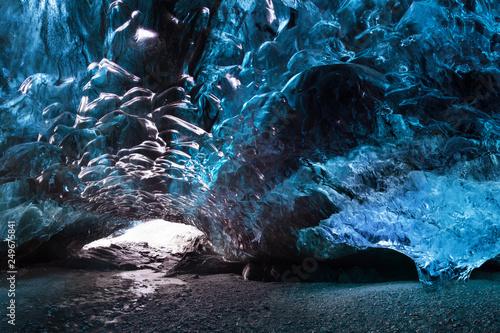 Blue crystal ice cave and an underground river beneath the glacier. Amazing nature of Skaftafell, Iceland. Photography inside of the glacier. Vatnajokull National Park, Iceland.