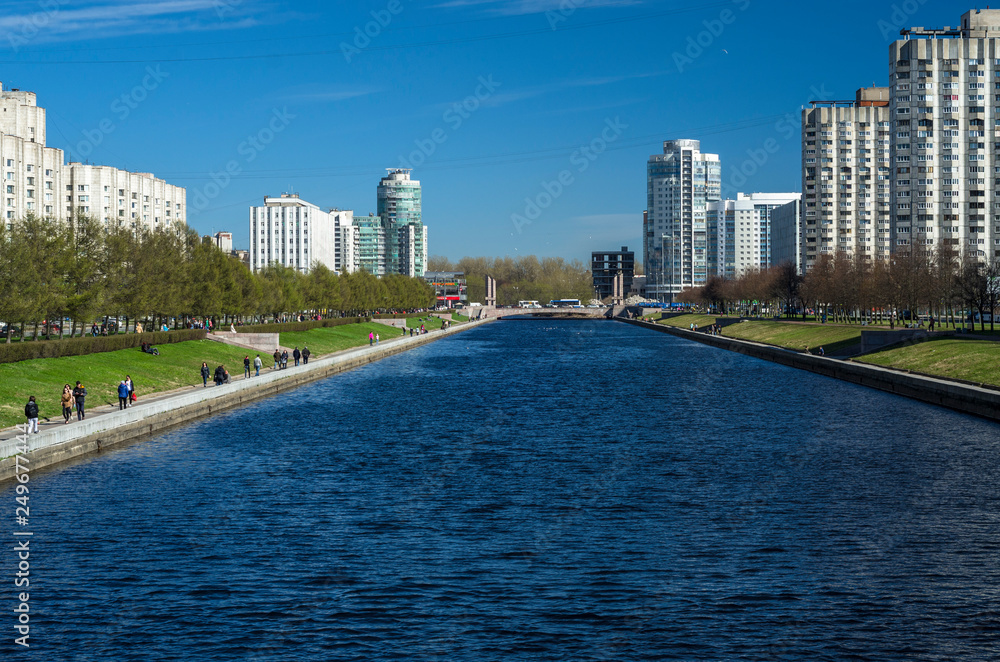 Perspective of the city river channel. The pedestrian embankment of the Smolenka River. Vasilievsky Island. Sunny spring weather. St. Petersburg, Russia, 1 May 2018 Perspective of the city river channel. The pedestrian embankment of the Smolenka River. Vasilievsky Island. Sunny spring weather. St. Petersburg, Russia, 1 May 2018