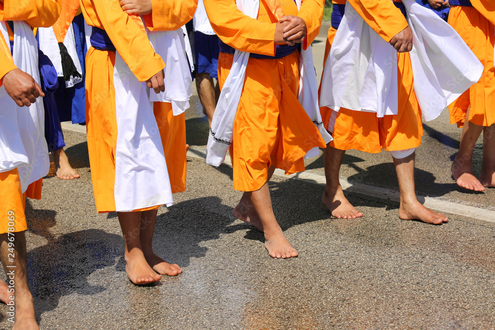 barefoot Sikh religion men during the parade in the city with or