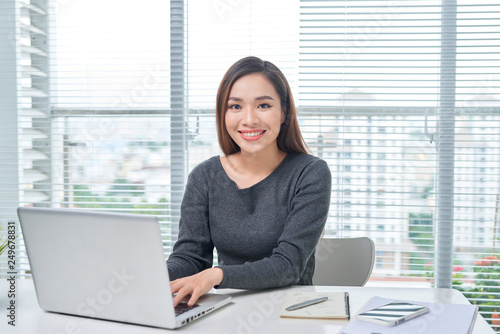 A beautiful lady sitting at a table. Office life. Work place. © makistock