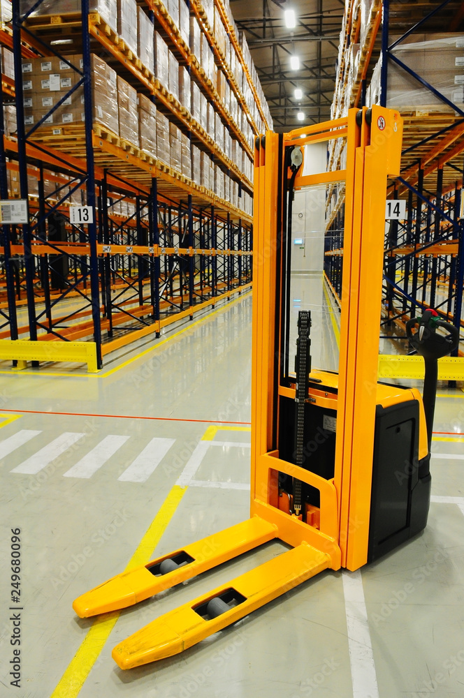 Yellow forklift in warehouse, industrial storage racking in background