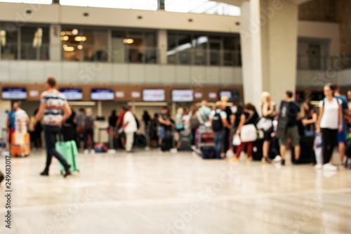 Photo on purpose defocused shows people waiting for check in at the airport.